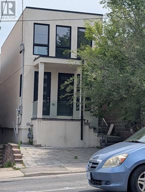 Toronto (Oakwood Village) apartment for rent - A blue car is parked in front of a two-story building.