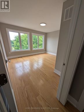 Toronto (Oakwood Village) apartment for rent - A room with wooden flooring and a window overlooking trees.
