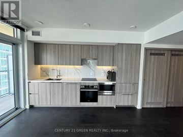 Toronto (Waterfront Communities) condo for rent - A modern kitchen with wooden cabinets and stainless steel appliances.