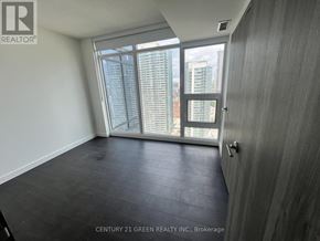 Toronto (Waterfront Communities) condo for rent - A room with a view of the city through a large window.