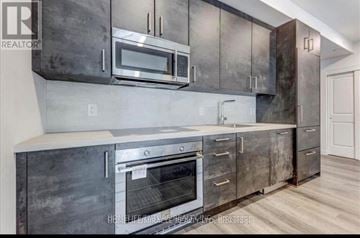 Niagara Falls (Brown) condo for rent - A modern kitchen with dark grey cabinets and stainless steel appliances.