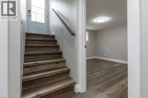 Hamilton apartment for rent - A wooden staircase with a white door and wall.