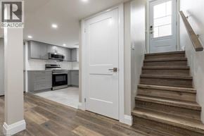 Hamilton apartment for rent - A modern kitchen with a white door and wooden stairs.