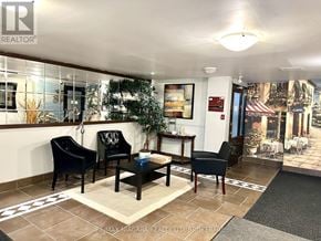 St. Catharines (Glendale/Glenridge) condo for rent - A waiting area with chairs and a table with a plant on it.