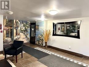 St. Catharines (Glendale/Glenridge) condo for rent - A black chair is in front of a wall with a picture of a street scene on it.