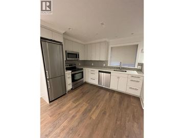 Vancouver apartment for rent - A kitchen with wooden floors and white cabinets.