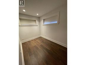 Vancouver apartment for rent - A room with wooden flooring and two windows with blinds.