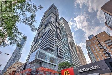 Toronto (Bay Street Corridor) condo for rent - A tall building with a striped facade stands in front of a McDonald's restaurant.