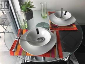 Toronto (Church-Yonge Corridor) condo for rent - A glass table with a white plate and silverware on it.