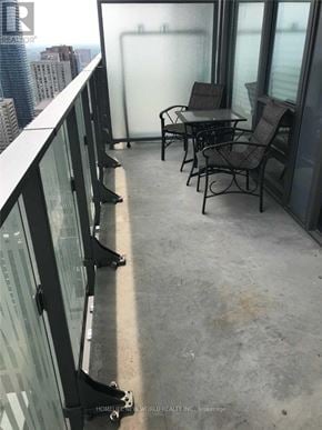 Toronto (Church-Yonge Corridor) condo for rent - A balcony with a glass railing and a table and chairs.