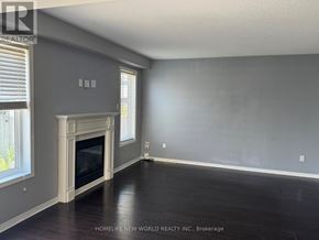 Oshawa (Pinecrest) apartment for rent - A large, empty room with a fireplace and wooden floors.