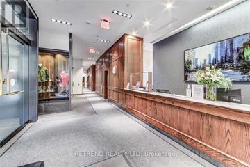 Toronto (Kensington-Chinatown) condo for rent - A spacious office lobby with a reception desk and a large screen TV mounted on the wall.