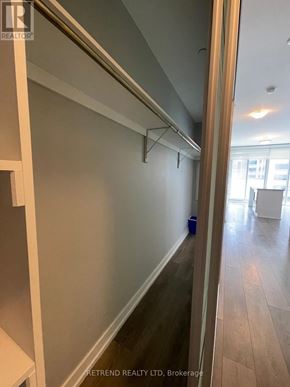 Toronto (Kensington-Chinatown) condo for rent - A hallway with a white wall and a wooden floor.