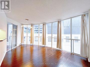 Toronto (Bay Street Corridor) condo for rent - A large, empty room with wooden floors and large windows.