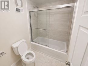 Mississauga (Erin Mills) apartment for rent - A white toilet in a bathroom with a glass shower door.