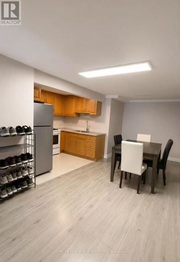 Mississauga (Erin Mills) apartment for rent - A kitchen with a refrigerator, a dining table with chairs, and a cabinet with a countertop.