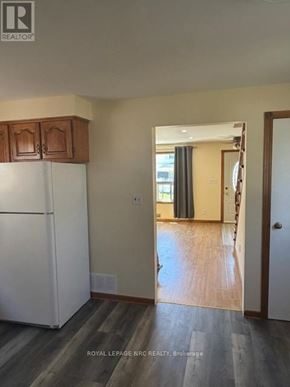 Welland (Lincoln/Crowland) apartment for rent - A white refrigerator in a kitchen with wooden cabinets.
