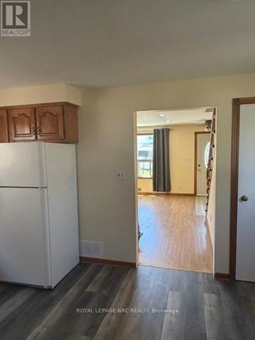 Welland (Lincoln/Crowland) apartment for rent - A white refrigerator in a kitchen with wooden cabinets.