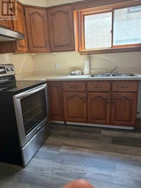 Welland (Lincoln/Crowland) apartment for rent - A kitchen with wooden cabinets and a black stove top oven.