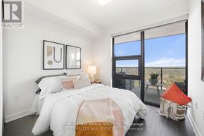 Toronto (Bay Street Corridor) condo for rent - A bedroom with a large bed and a view of the outdoors through a sliding glass door.
