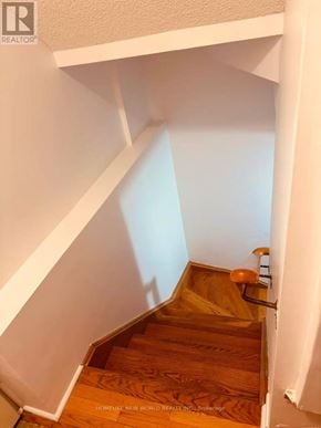 Mississauga (Cooksville) townhouse for rent - A wooden staircase with a white wall on the side.