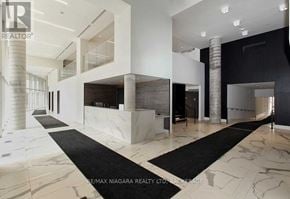 Vaughan (Concord) condo for rent - A spacious hallway with marble floors and a black and white runner.