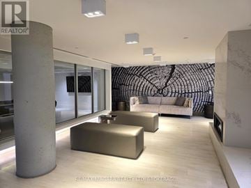 Vaughan (Concord) condo for rent - A modern living room with a large sofa and a patterned wall hanging.