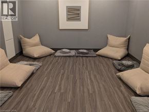 Hamilton condo for rent - A room with a grey wall and a wooden floor with a rug and four pillows.