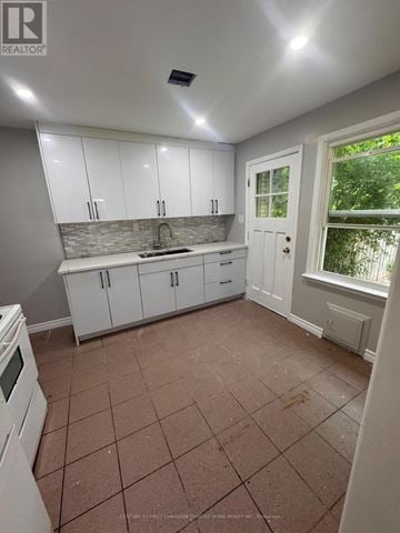 London South (South R) townhouse for rent - A kitchen with white cabinets and a tiled floor.