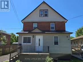 Fort Erie (Central) triplex for rent - A house with a white door and a black railing.