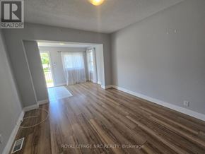 Fort Erie (Central) triplex for rent - A room with wooden flooring and a doorway leading to another room.