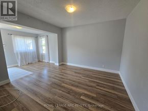 Fort Erie (Central) triplex for rent - A room with wooden flooring and white walls.