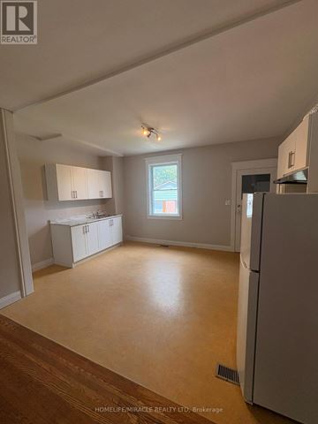 Toronto (Oakwood Village) apartment for rent - A kitchen area with a refrigerator, cabinets, and a window.