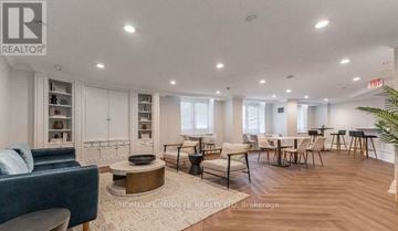 Toronto (Church-Yonge Corridor) condo for rent - A well-lit, spacious living room with a blue sofa and a coffee table.