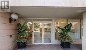 Toronto (Church-Yonge Corridor) condo for rent - A realtor office entrance with glass doors and two potted plants.