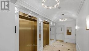 Toronto (Church-Yonge Corridor) condo for rent - A hallway with two elevators and a chandelier hanging from the ceiling.