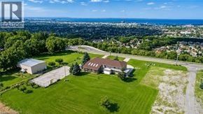 Hamilton apartment for rent - A large house with a green lawn in front of a cityscape.