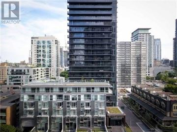 Toronto (Mount Pleasant West) condo for rent - A cityscape with a large building in the foreground and other buildings in the background.