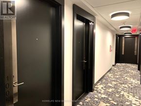 Toronto (Mount Pleasant West) condo for rent - A hallway with black doors and a red exit sign.