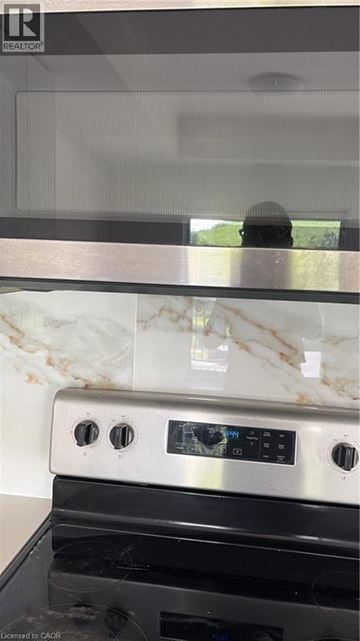 Kitchener townhouse for rent - A modern kitchen with a stove top oven and a marble backsplash.