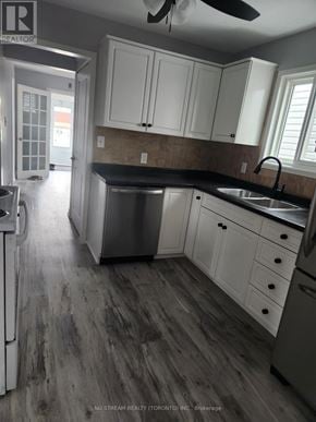 Niagara Falls (Clifton Hill) apartment for rent - A kitchen with white cabinets and a black countertop.