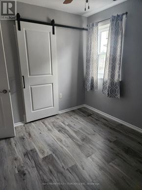 Niagara Falls (Clifton Hill) apartment for rent - A room with a sliding door and a window with curtains.