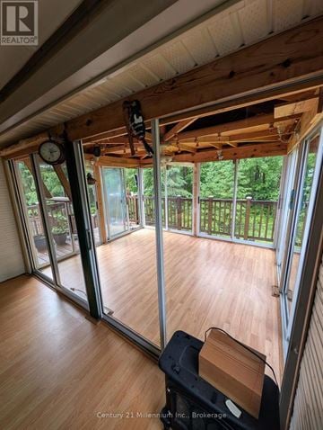 Wasaga Beach apartment for rent - A room with wooden floors and a ceiling that is partially open to the outside.