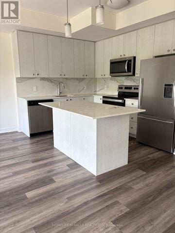Kitchener townhouse for rent - A kitchen with a white island and stainless steel appliances.