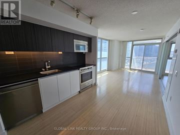 Toronto (Waterfront Communities) condo for rent - A spacious kitchen with wooden floors and modern appliances.