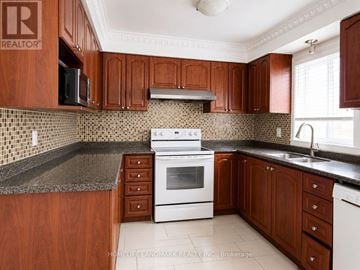 Markham (Middlefield) apartment for rent - A kitchen with wooden cabinets and a white stove top oven.