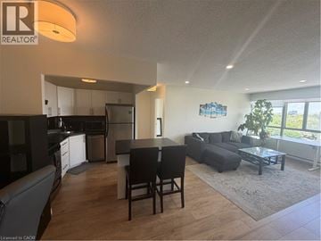 Kitchener condo for rent - A well-lit living room with a dining table and chairs.
