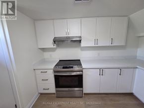 St. Catharines (Secord Woods) apartment for rent - A kitchen with white cabinets and a stainless steel range hood.