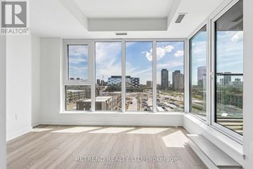 Toronto (Banbury-Don Mills) condo for rent - A large, empty room with a view of a city skyline through the windows.