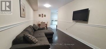 Markham (Cornell) townhouse for rent - A living room with a grey couch and a television mounted on the wall.